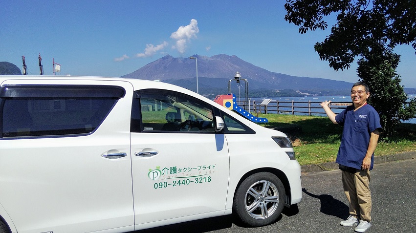 埼玉県への超長距離搬送を前に、鹿児島の桜島を背景にする弊社車両